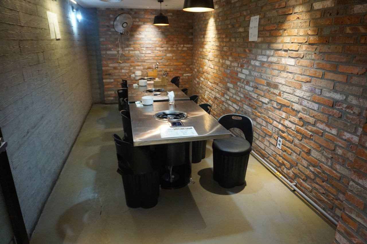 벽돌 벽 룸 좌석과 단체 테이블